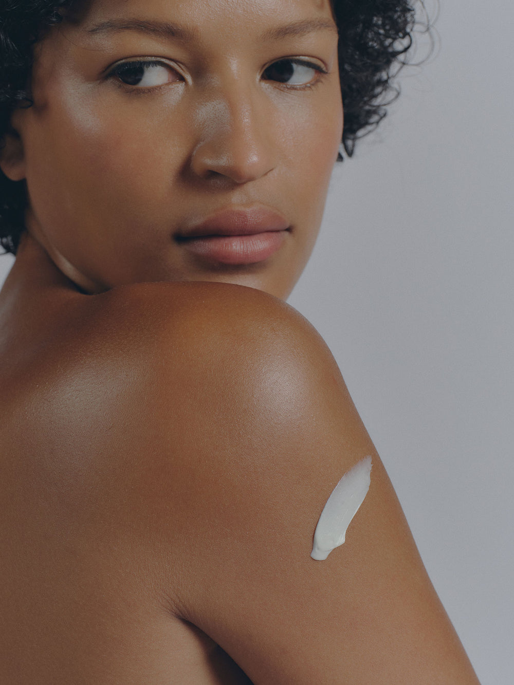 Manuka Rich Cream lightly placed on woman overlooking her shoulder