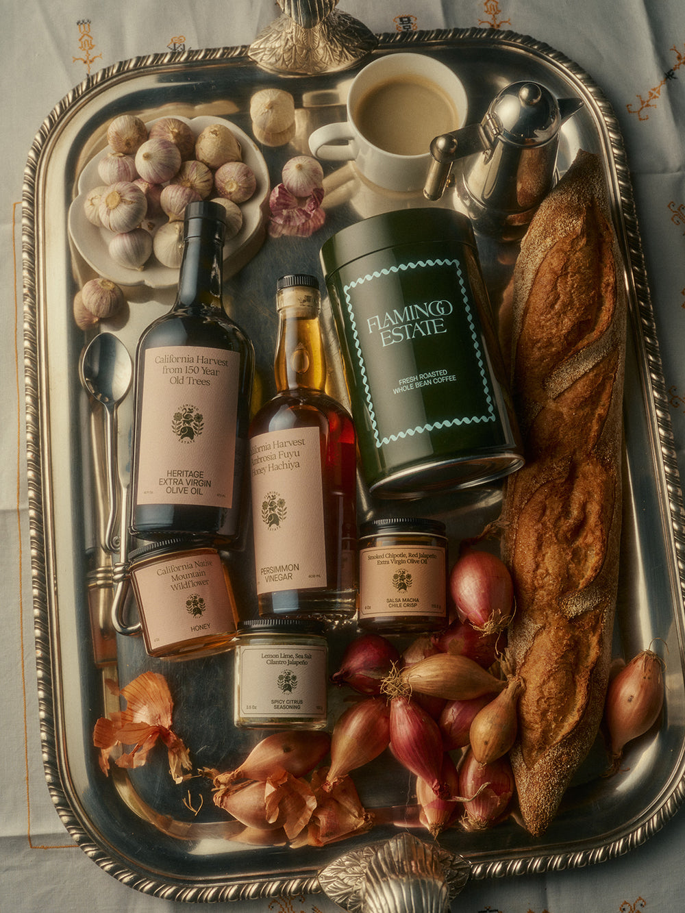 A silver tray holds various gourmet items including a coffee container labeled