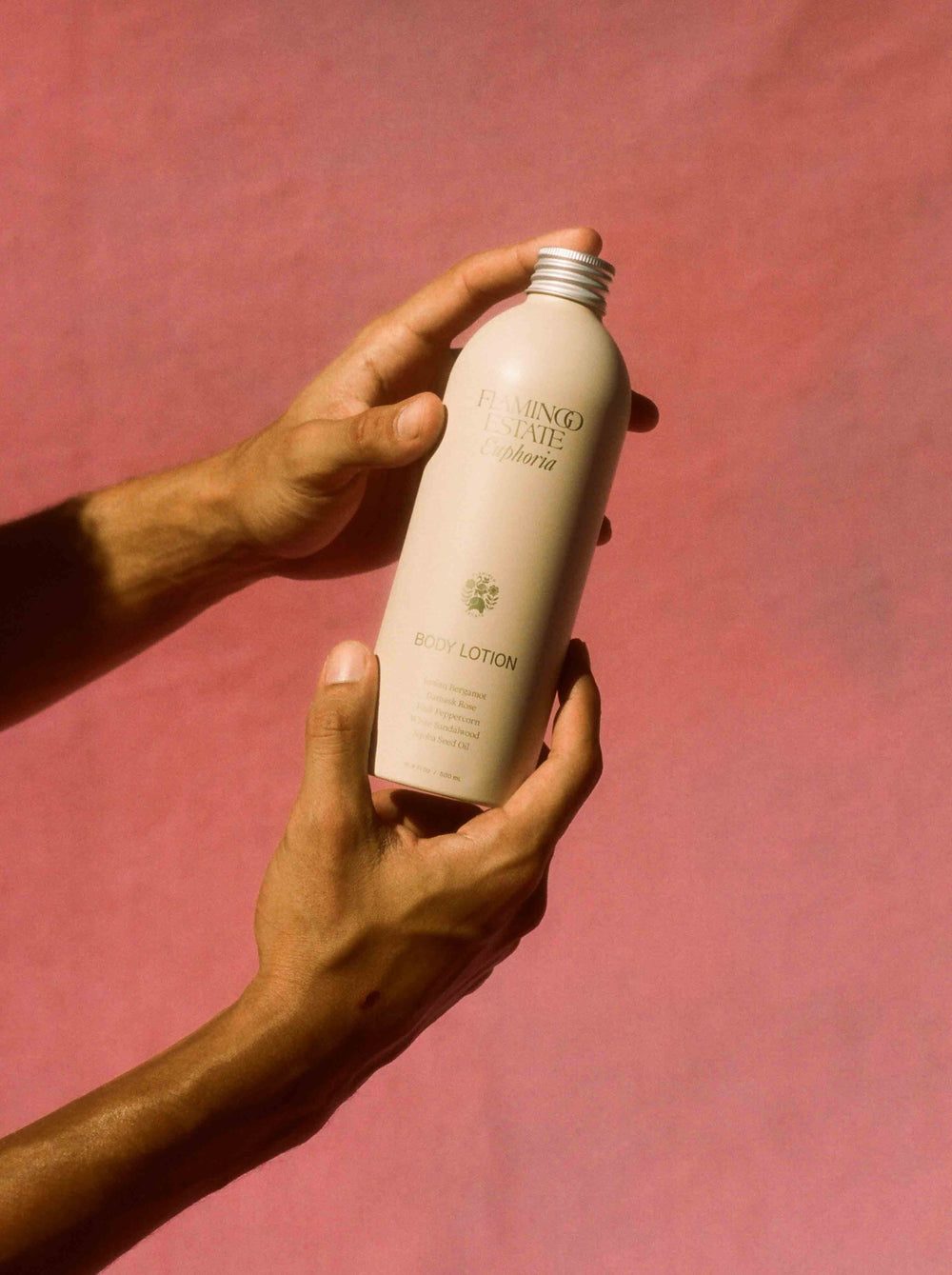 Two Hands Holding A Bottle Of Flamingo Estate