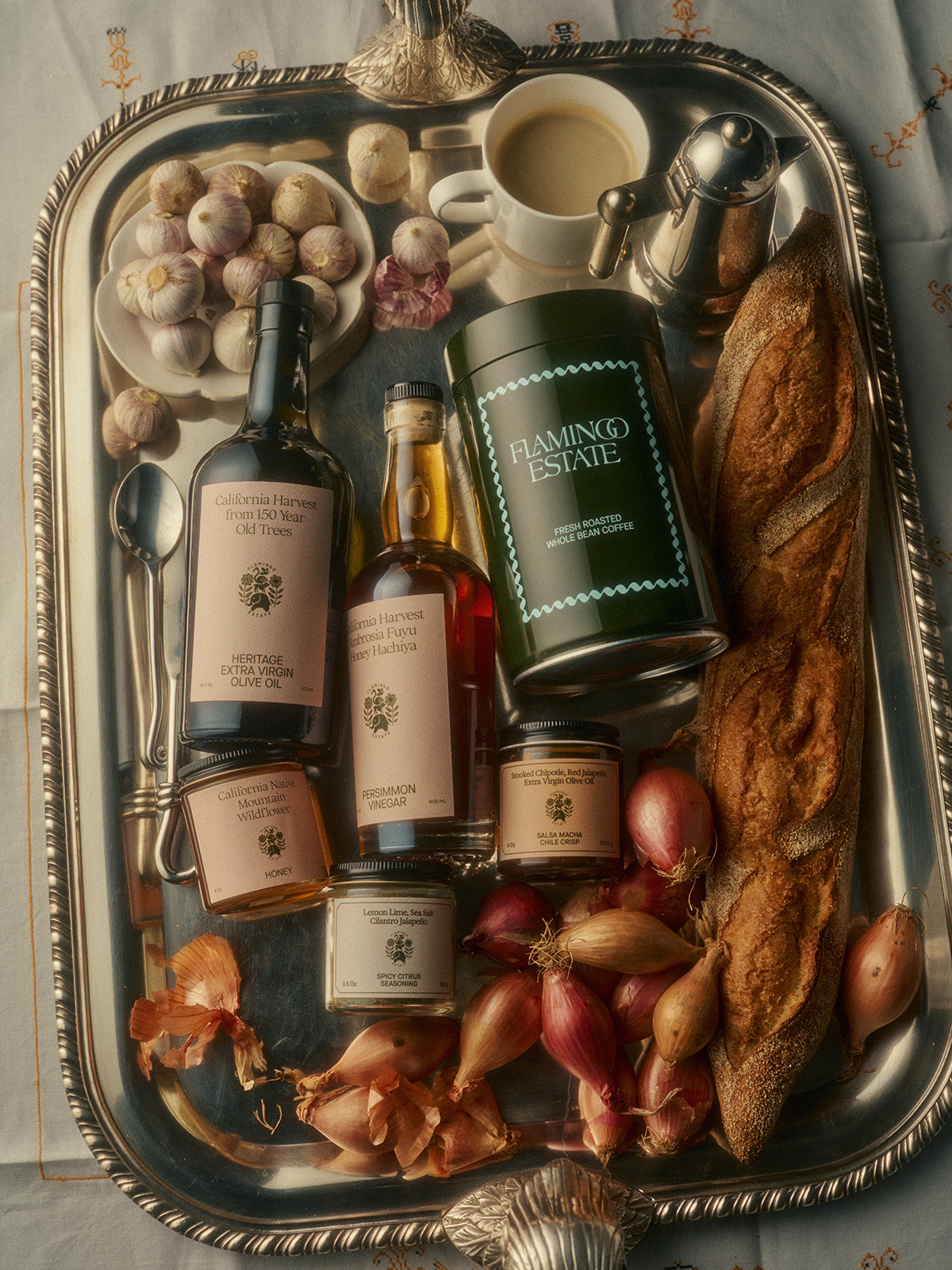 A silver tray holds various gourmet items including a coffee container labeled 