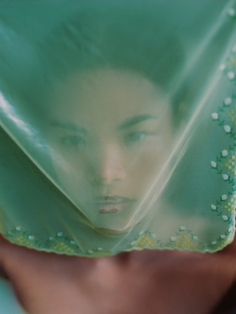 Woman wearing a green headscarf with floral patterns