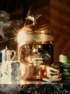 Copper espresso machine with an eagle on top emits steam.