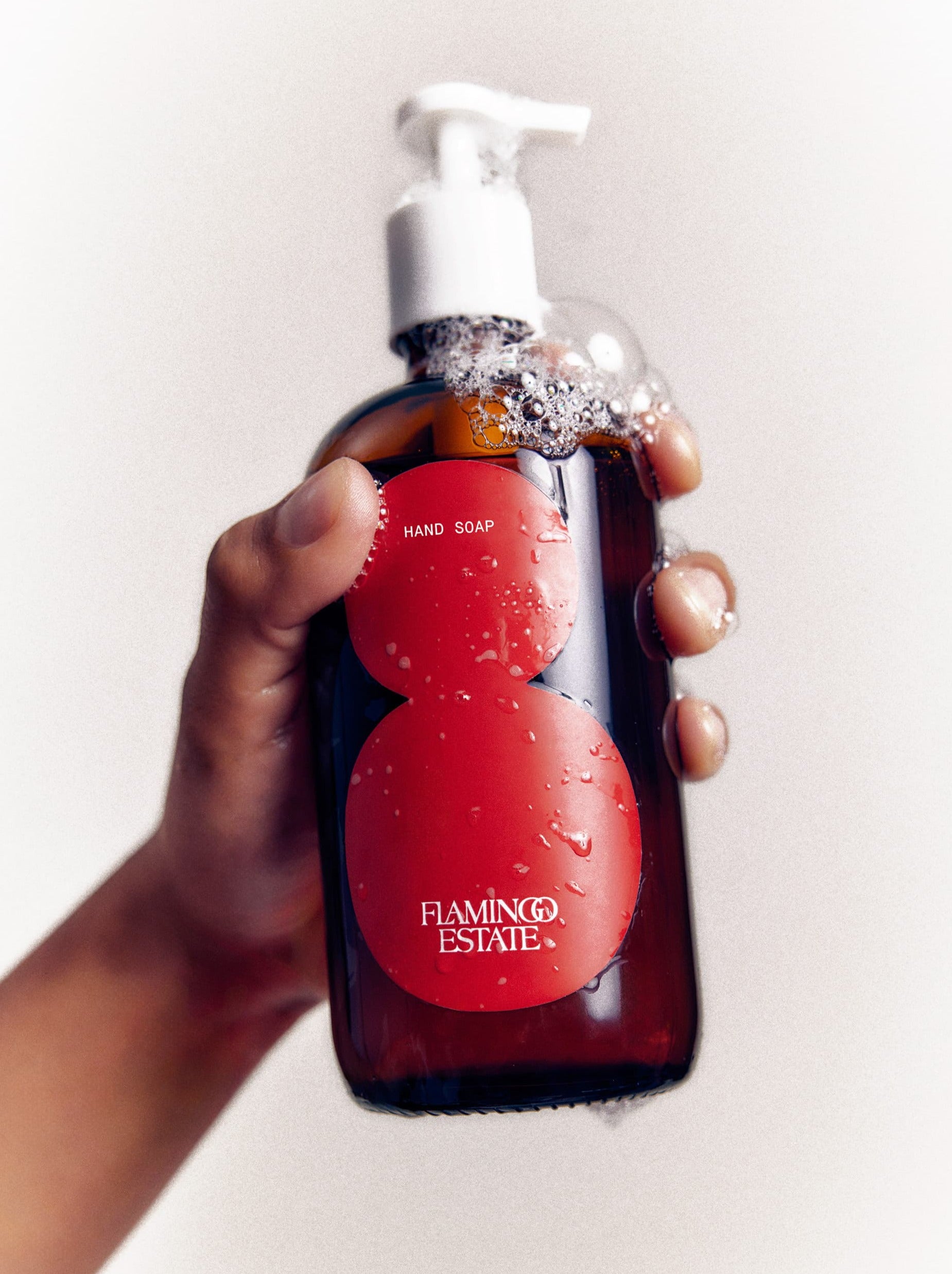 Hand Holding A Foaming Roma Heirloom Tomato Hand Soap Bottle