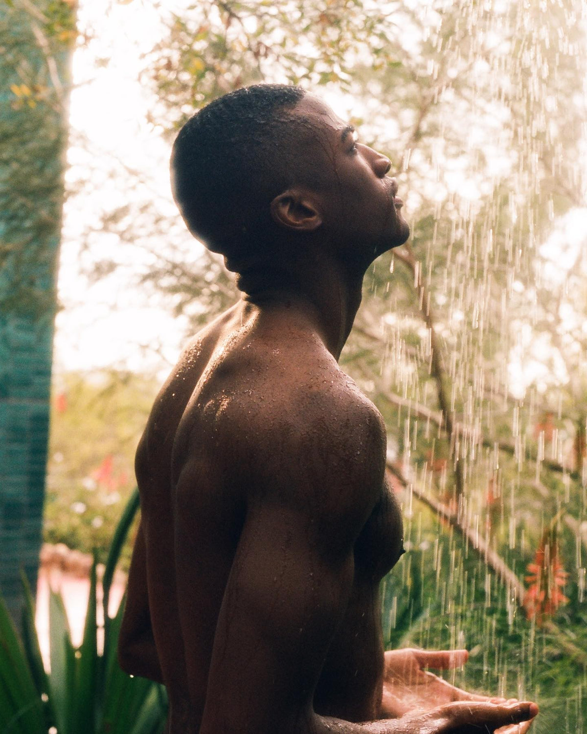 A person stands with eyes closed, facing upward.